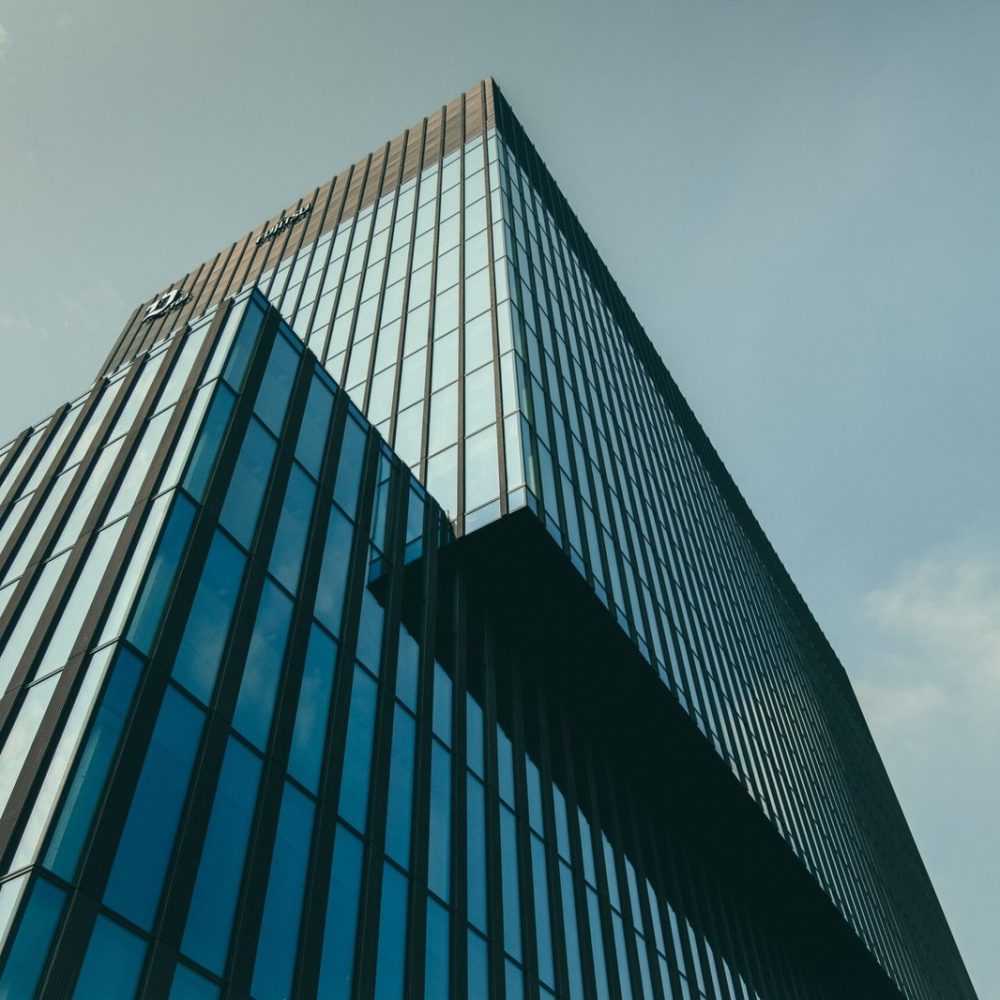 low-angle-view-building-glass-facade-beautiful-cloudy-sky-scaled.jpg